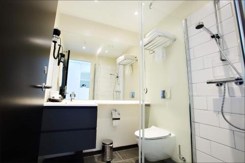 a bathroom with a shower and a toilet and a sink at Hotel Hafnia in Tórshavn