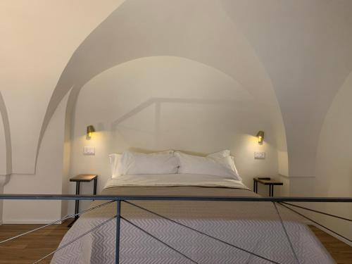 Bett in einem weißen Zimmer mit 2 Tischen in der Unterkunft Il Sogno di Mimì in Polignano a Mare