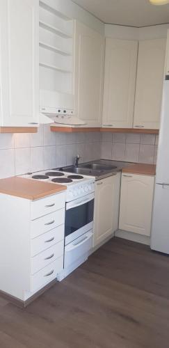 Kauhajoki的住宿－Vuolteentie 38 D 26，厨房配有白色橱柜和炉灶烤箱。