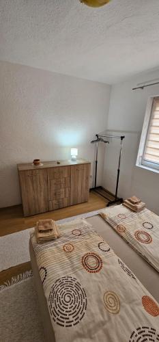 dwa łóżka w pokoju z oknem w obiekcie Apartman Naza w mieście Kulen Vakuf