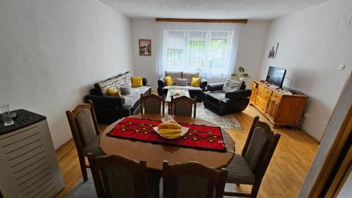 un soggiorno con tavolo e una sala da pranzo di Apartman Naza a Kulen Vakuf