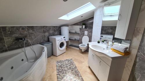 a bathroom with a tub and a sink and a toilet at Apartmani Bajić in Orebić