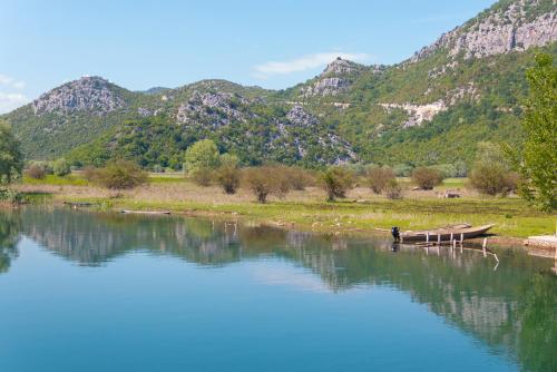 a boat on the water with mountains in the background at Pristan Apartments in Dodoši
