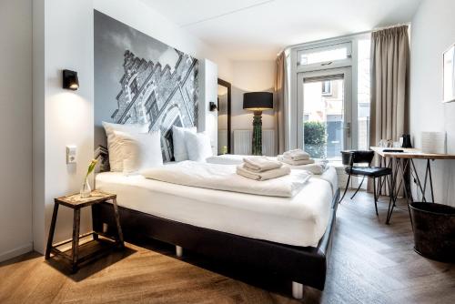 a bedroom with a large bed with white sheets at Broeck Oudewater in Oudewater