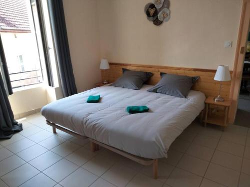 ein Schlafzimmer mit einem großen Bett mit zwei grünen Platten darauf in der Unterkunft Gîte de la tour in Guillon