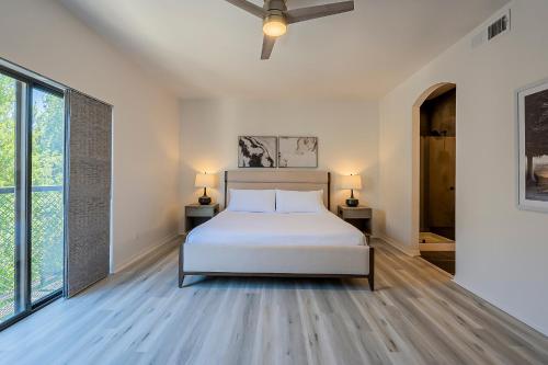 a white bedroom with a bed and two windows at Modern 3 Bed - 3 Bath Townhouse w/ rooftop deck in Phoenix