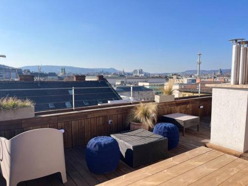 uma varanda com bancos e mesas azuis num telhado em Stylish apartment with shared rooftop terrace/jacuzzi em Budapeste
