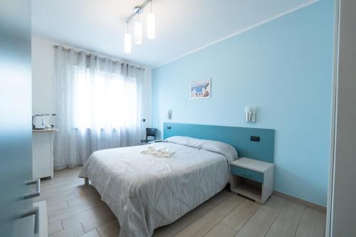 a blue bedroom with a bed and a blue wall at Appartamento Pettinato in Pizzo