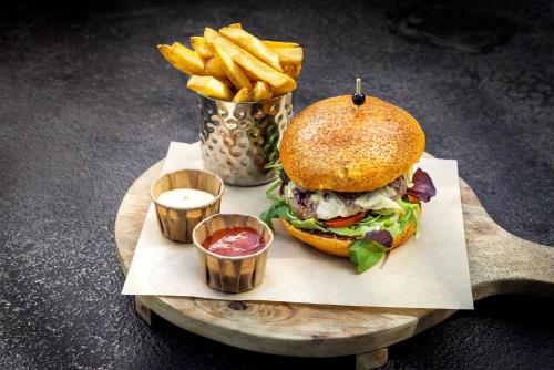 a sandwich and french fries on a wooden tray at Broeck Oudewater in Oudewater