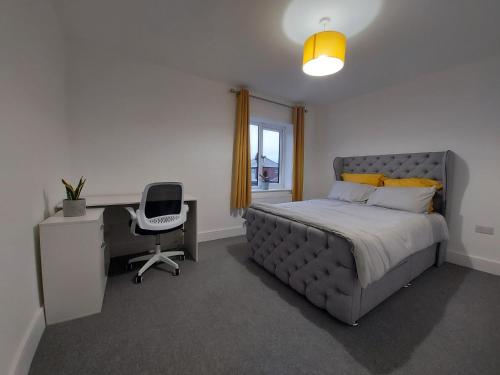 a bedroom with a bed and a desk and a chair at Luxury home away from home in Manchester