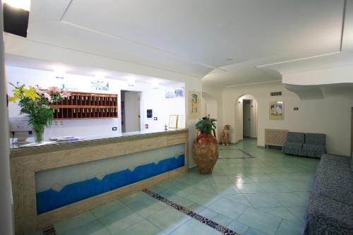 a lobby with a bar with a vase in the middle at Hotel Albatros in Ischia