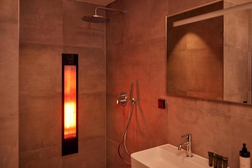 a bathroom with a shower with a sink and a mirror at Hotel Gorinchem in Gorinchem