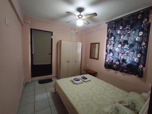 a bedroom with two beds and a ceiling fan at Niki's house 1 in Agia Triada