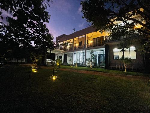 un edificio con luces en el patio por la noche en Black Mustang Hotel en Dambulla