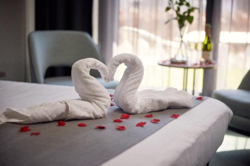 two towels shaped like swans sitting on a bed at Hotel Gorinchem in Gorinchem