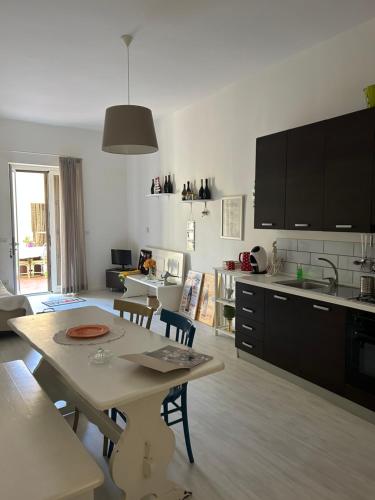 a living room with a table and a kitchen at Casa Pinù in San Michele di Ganzaria