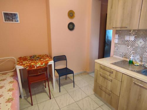 a kitchen with a table and two chairs and a table at Niki's house 1 in Agia Triada