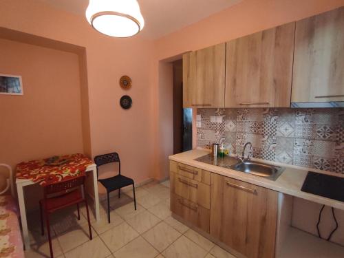 a kitchen with a sink and a table with a chair at Niki's house 1 in Agia Triada