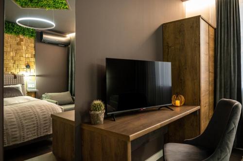 a living room with a television and a bed at Какао Апартамент Велинград in Velingrad