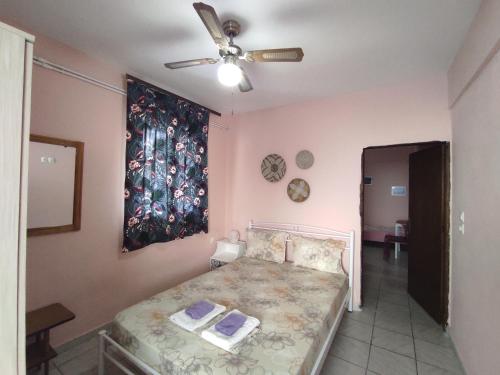 a bedroom with a bed and a ceiling fan at Niki's house 1 in Agia Triada
