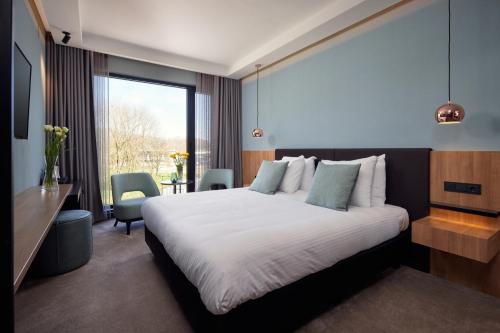 Pokój hotelowy z łóżkiem, biurkiem i oknem w obiekcie Hotel Gorinchem w mieście Gorinchem