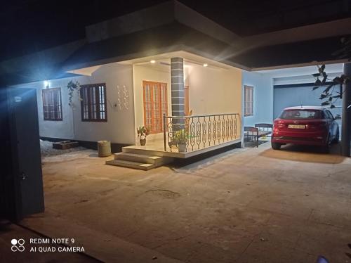 un coche aparcado delante de una casa por la noche en FAB HOUSE en Thekkadi