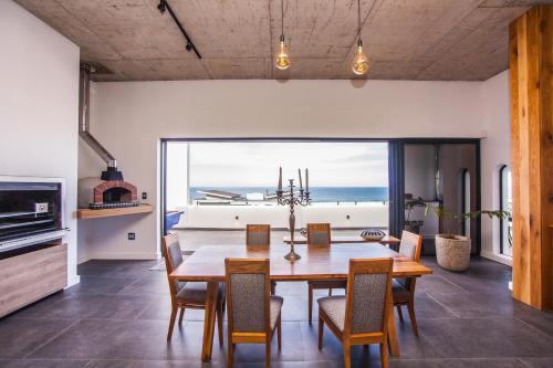 a dining room with a table and chairs and a view of the ocean at Yzerfontein Villa Fantastica - No Loadshedding in Yzerfontein