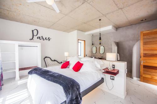 a bedroom with a large white bed with red pillows at Yzerfontein Villa Fantastica - No Loadshedding in Yzerfontein