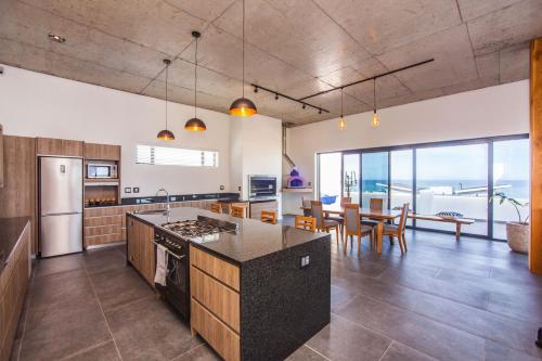 an open kitchen and dining room with a view of the ocean at Yzerfontein Villa Fantastica - No Loadshedding in Yzerfontein
