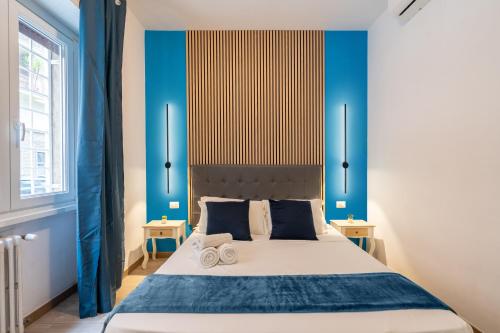 een slaapkamer met een groot bed met blauwe muren bij near San Pietro - Rome Vatican Suites in Rome