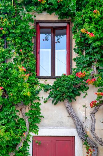 a building with a red door and a window at Casa Zefìra in Feltre