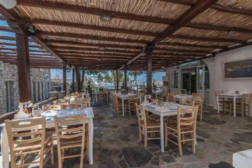 a restaurant with tables and chairs and a ceiling at Makis Place in Tourlos