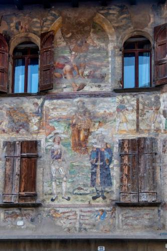 a painting on the side of a building with windows at Casa Zefìra in Feltre