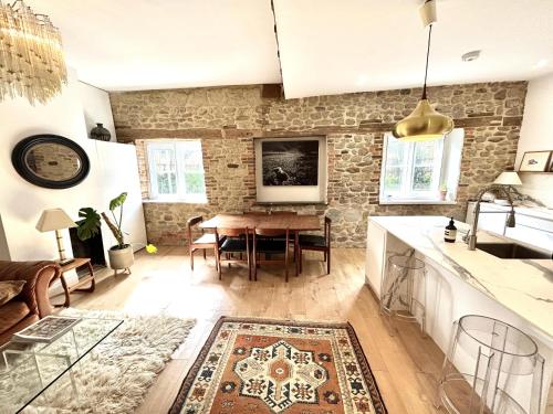 a kitchen and living room with a wooden table at 3 Bed Cottage - Sleeps 6 - Pets - Parking - Wifi in Petworth