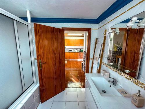 a bathroom with a sink and a wooden door at Luana House in Biscoitos