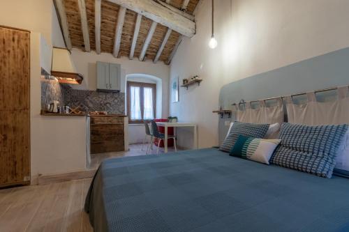 een slaapkamer met een blauw bed en een keuken bij A Casa Di Gaia in Riccò del Golfo di Spezia