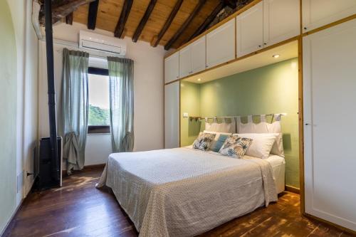 een slaapkamer met een bed en een groot raam bij A Casa Di Gaia in Riccò del Golfo di Spezia