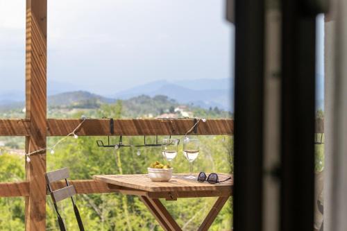 a table with glasses and a bowl of fruit on a balcony at A Casa Di Gaia in Riccò del Golfo di Spezia