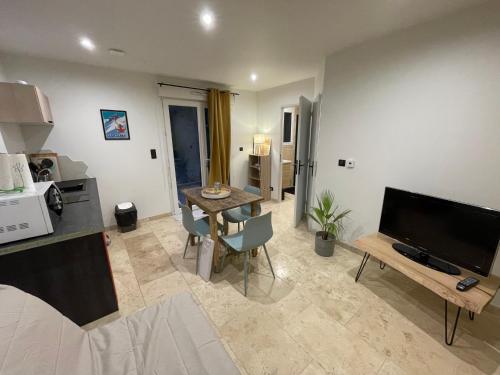 un salon avec une télévision et une table dans l'établissement L'Evasion à la Tourronde, à Gap