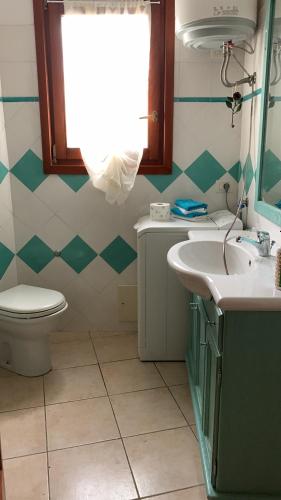 ムルタ・マリアにあるLa Tana del Dragoのバスルーム(トイレ、洗面台付)、窓が備わります。