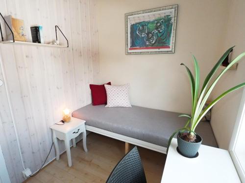 Habitación pequeña con cama y planta en Linda's Apartment, en Sörsjön