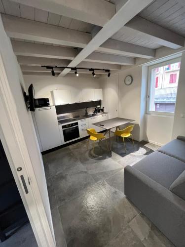 ein Wohnzimmer mit einem Tisch und einer Küche in der Unterkunft La Casa Incartata in Toscolano-Maderno