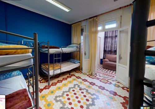 1 dormitorio con literas y pared azul en Albergue Internacional de Teruel City Backpackers, en Teruel