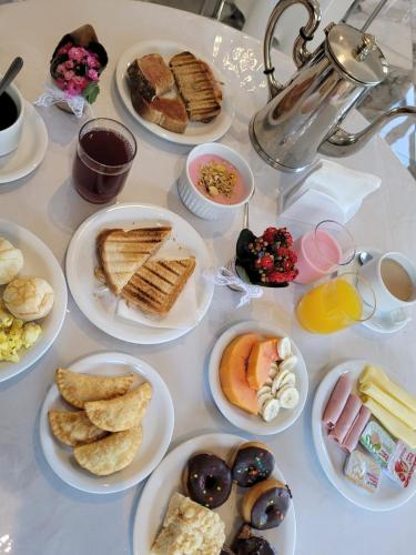a table with plates of breakfast foods on it at Pousada do Pórtico in Gramado