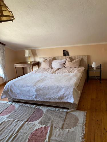 1 dormitorio con 1 cama grande con sábanas y almohadas blancas en Wohnung in Kärnten Nähe Millstättersee, en Fresach