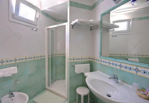 a bathroom with a sink, toilet and tub at Hotel Albatros in Ischia