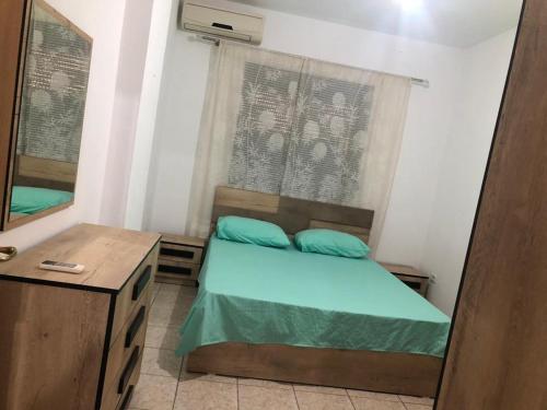 Dormitorio pequeño con cama y espejo en Apartament rohelio shkembi kavajes en Durrës