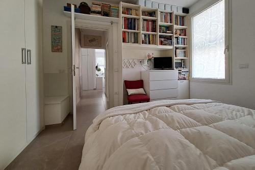 a bedroom with a bed and a window and bookshelves at Appartamento al mare in Pesaro