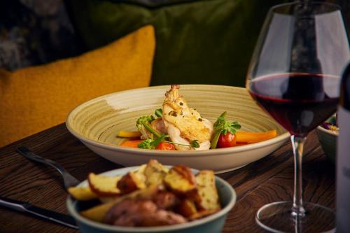 a table with two bowls of food and a glass of wine at Hotel Gorinchem in Gorinchem