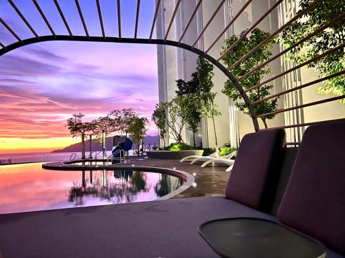 a view of a building with a pool and a sunset at The Shore CBD Kota Kinabalu By LAXZONE SUITE in Kota Kinabalu